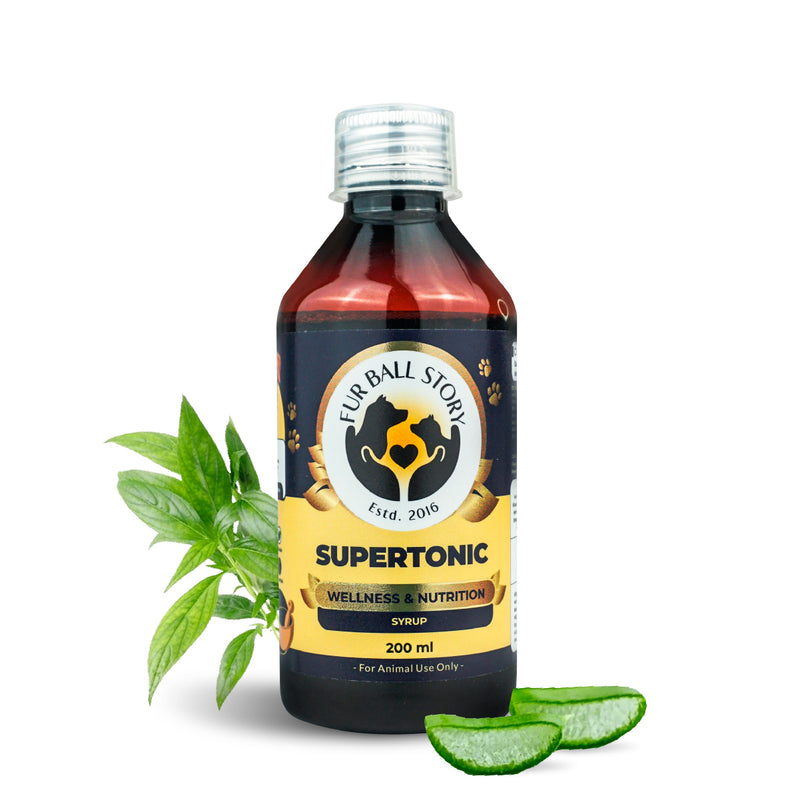 A 200ml bottle of Fur Ball Story Supertonic centered between fresh, vibrant green Moringa leaves and sliced Aloe Vera, suggesting a farm-to-pet wellness philosophy.