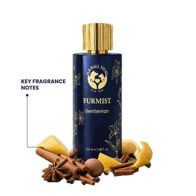 A dark blue and gold bottle of Furmist Gentleman pet fragrance surrounded by raw ingredients like cinnamon sticks, star anise, cloves, and lemon slices.