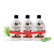 Three bottles of Shampooch dog shampoo tied together with a red ribbon gift bow, flanked by aloe vera leaves.