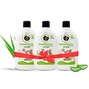 Three 300 ml bottles of Fur Ball Story Shampooch Tick-Free dog shampoo tied together with a red gift ribbon, flanked by fresh aloe vera.